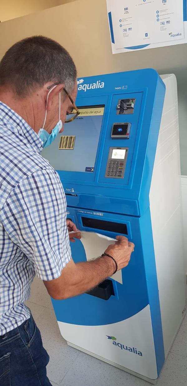 Un usuario pagando su recibo a través del cajero en la oficina de Aqualia en Arcos de la Frontera